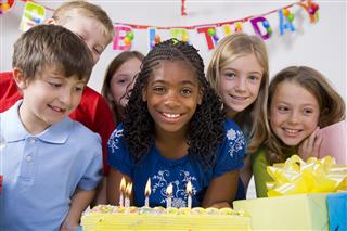 Children Blowing Out Candles on a Birthday Cake