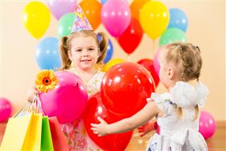 Pretty children with colorful balloons and gifts on birthday party