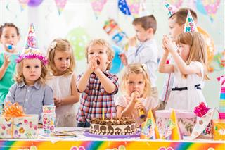 Group of cheerful children celebrating birthday and singing