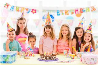 Group of happy children at birthday party looking at camera
