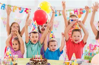 Happy children celebrating and singing at birthday party