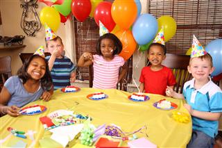 Smiling children eating cake at a birthday party