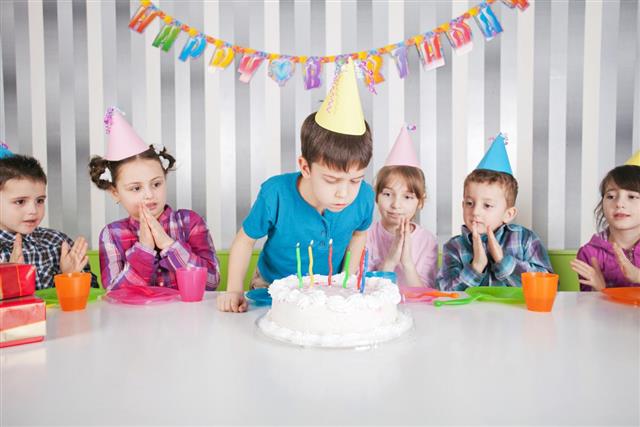 Cute boy blowing candles on birthday cake