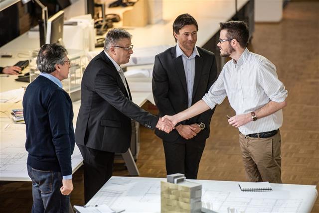 Architect Shaking Hand With Client In Office