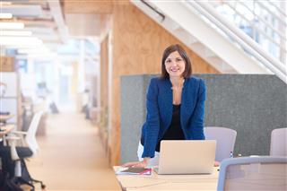 Smiling Businesswoman Standing At Desk