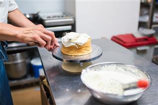 Baker Spreading Cream Over Cake