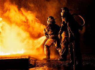 Firefighters With Water And Hose