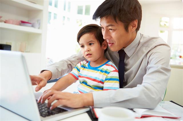 Man Working From Home With Son