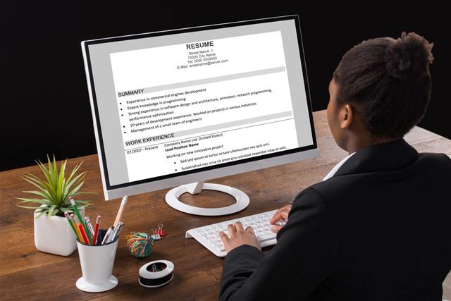 Businesswoman Analyzing Resume On Computer