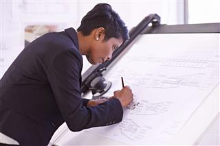 Female Architect Working At Drawing Board
