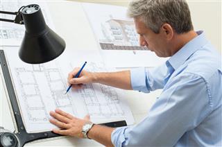 Architect Working At Drawing Table