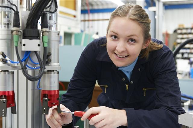 Young Woman Working On Machinery In A Factory