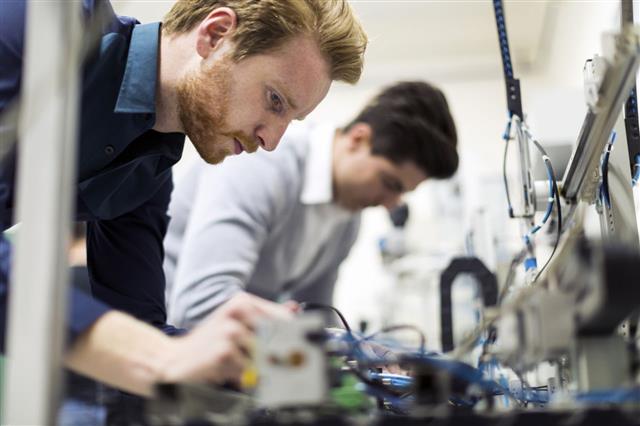 Two Engineers Working On Electronics Components
