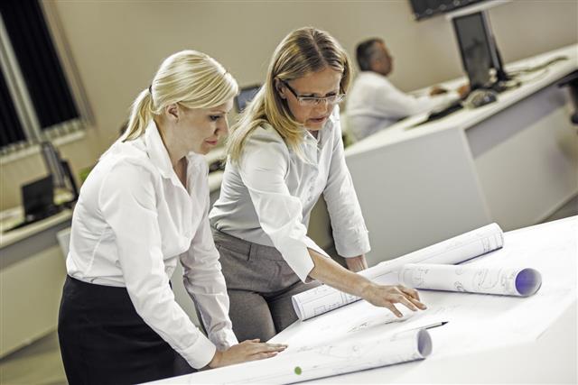 Female Engineers Reviewing Blueprints Together
