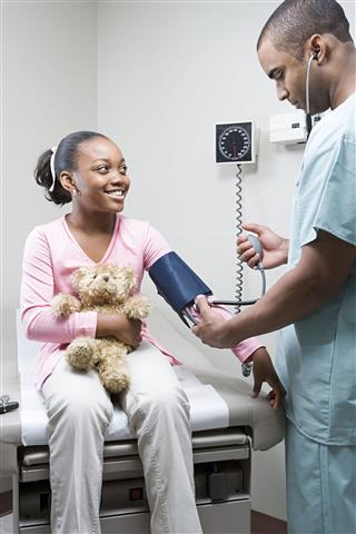 Doctor Checking Girls Blood Pressure