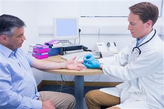 Doctor Using A Blood Glucose Meter