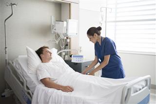 Man In Hospital Bed With Nurse