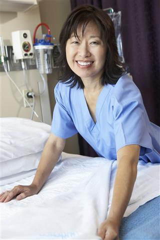 Nurse Making Bed In A Hospital