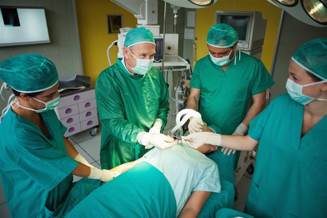 Smiling Surgeon Taking A Scalpel