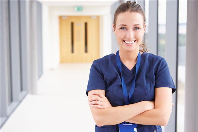 Smiling Female Nurse In Hospital Corridor