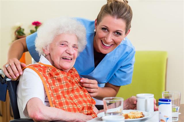 Nurse With Woman Helping With Meal