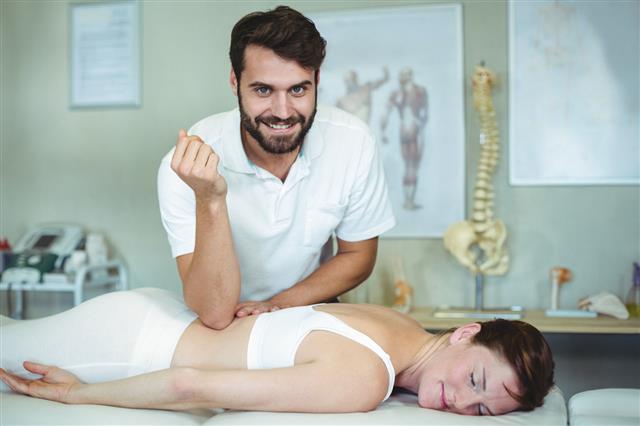 Physiotherapist Giving Back Massage To Woman