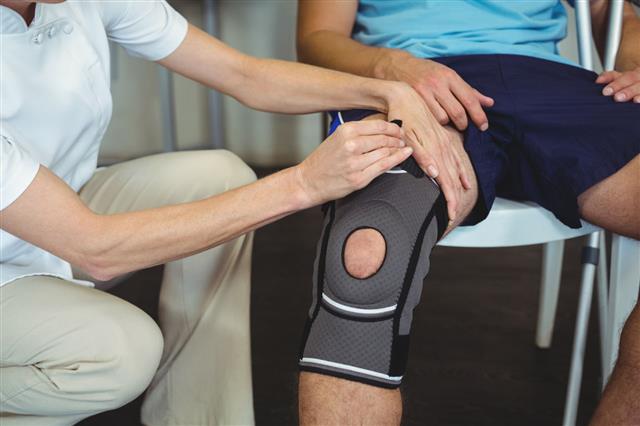 Physiotherapist Examining Patients Knee
