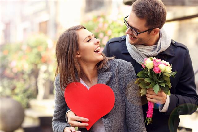 Man Surprising Woman With Flowers And Heart