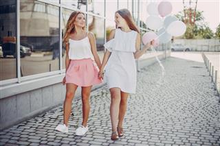 Two Girls Walking With Balloons