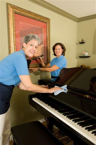 Cheerful Maids Dusting Picture And Piano