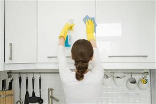 Woman Cleaning Kitchen Wall Cabinet