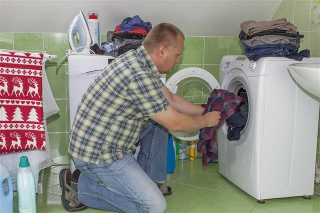 Man Washes Clothes In Washing Machine