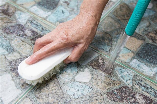 Woman Hand Cleaning Floor Tiles