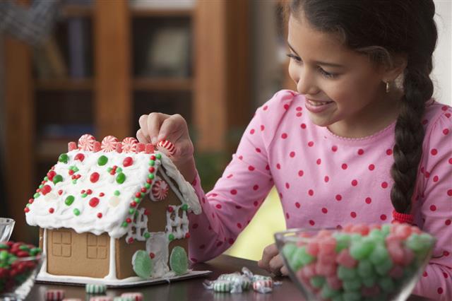 Girl Decorating Gingerbread House