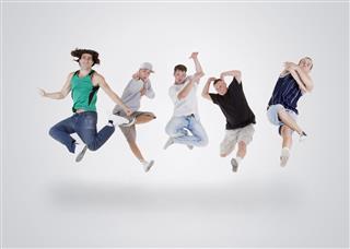 Young Teenagers Jumping Over White