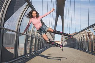 Beautiful Young Brunette Jumping On A Bridge
