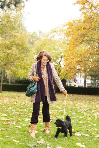 Senior Woman Walking With Her Dog