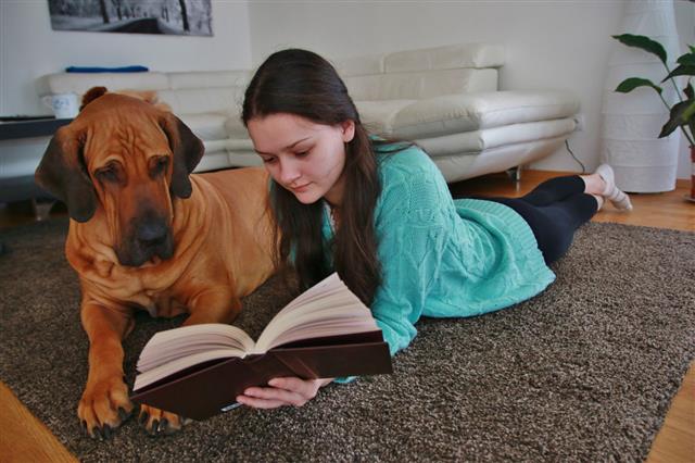 Girl Reading A Book With Dog