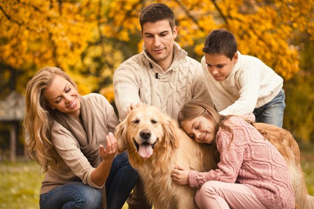 Family And Dog Enjoying Autumn Day