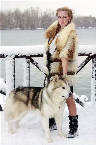Woman With Wolf Dog In Snow
