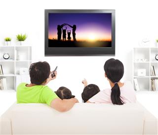 Family Watching Tv In Living Room