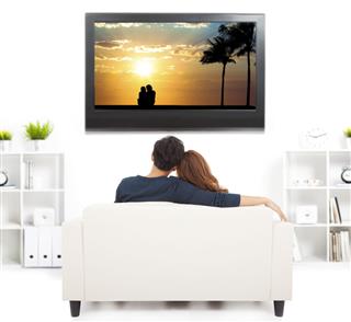 Young Couple On Sofa Watching Tv