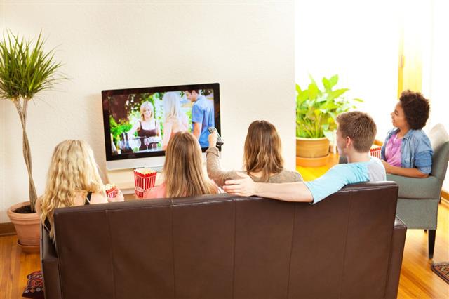Group Of Young Friends Watching Television