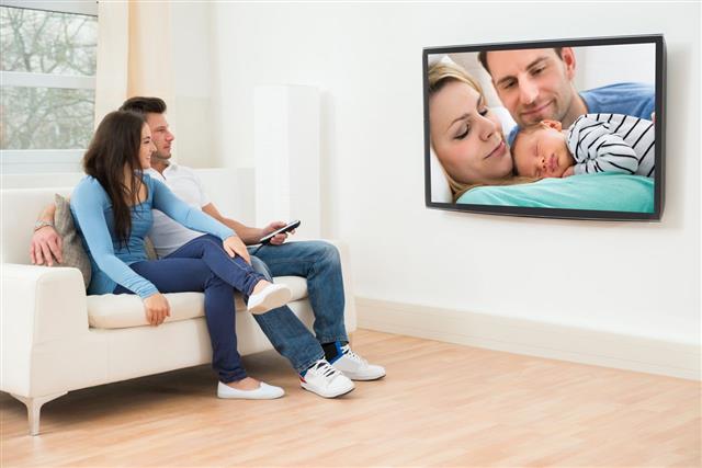 Young Couple In Watching Television