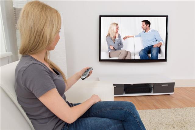 Woman With Remote Control Of Television