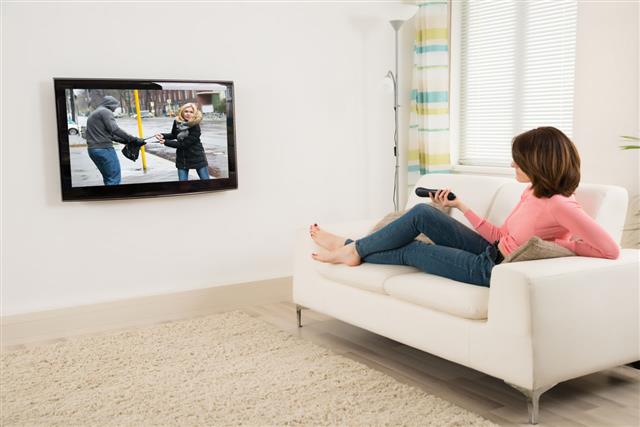 Woman Holding Remote While Watching Television