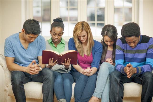 Teenagers Praying During Bible Study