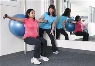 Pregnant Woman Working Out With Trainer