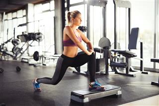 Young Woman Doing Lunges At Gym