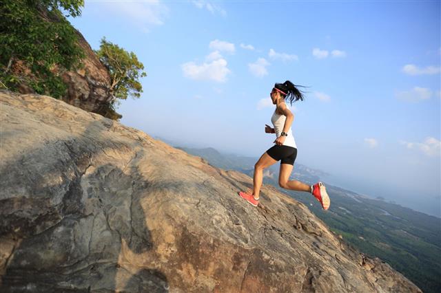 Young Woman Running On Mountain Peak